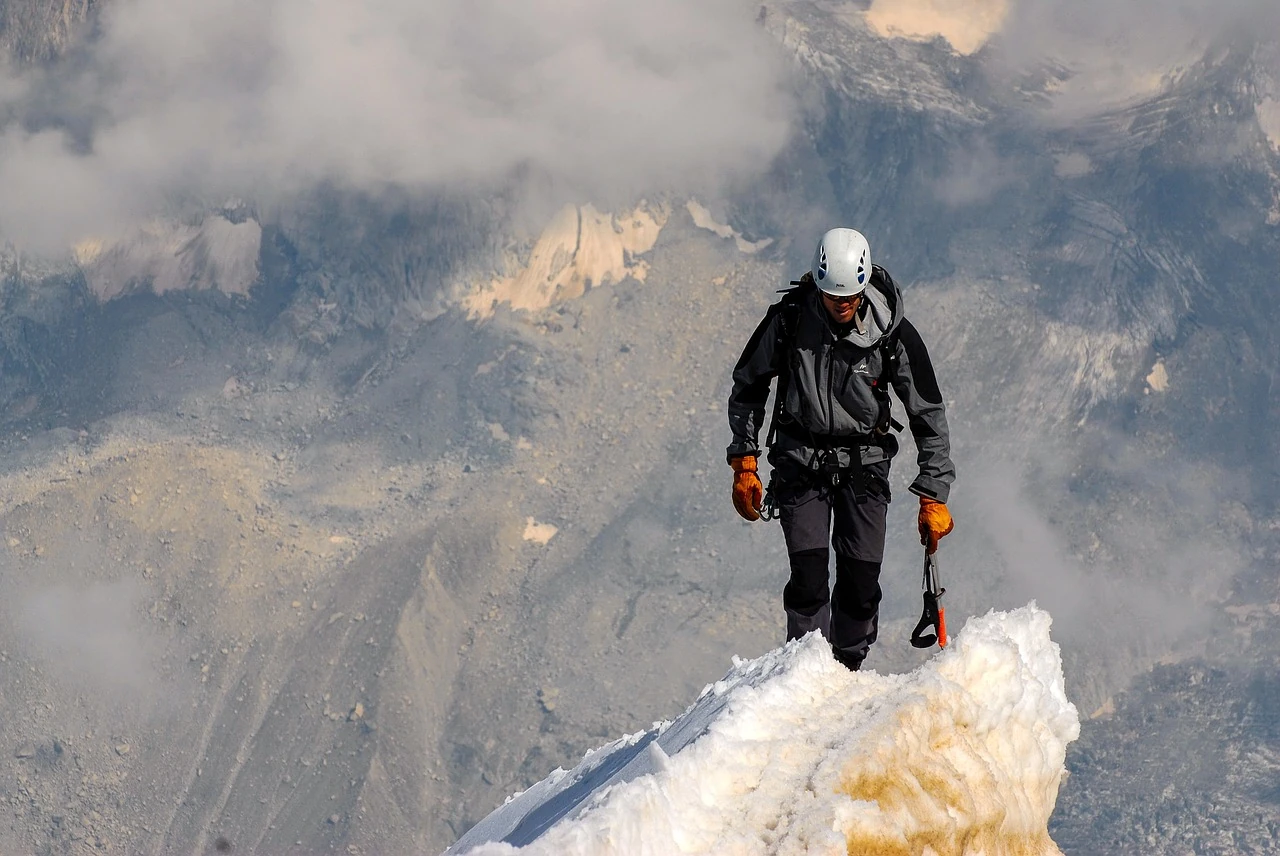 Illustration of a determined hiker ascending a mountain made of books labeled in different languages, symbolizing gradual language learning progress.
